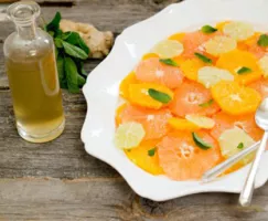 Ginger Mint Citrus Salad in a white bowl with a side of dressing