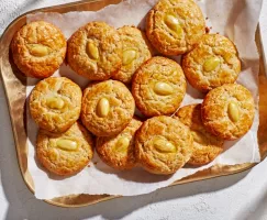 A baker’s dozen golden almond cookies on a brass tray.