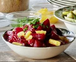 A bowl of orange and glazed beets