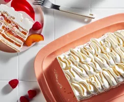 Peach melba icebox cake shown on a peach platter garnished with a peach slice and raspberries