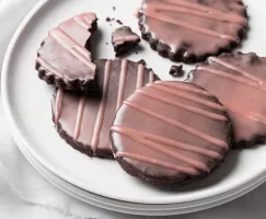 Chocolate cookies with a dark pink glaze on a plate