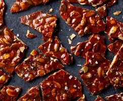 Broken pieces of pumpkin seed brittle on a dark background