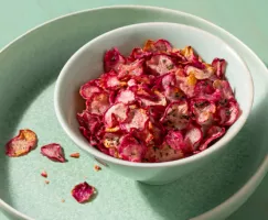 White bowl of rosemary radish chips on a green platter
