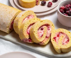 Slices of vanilla Swiss roll filled with cranberries and cream