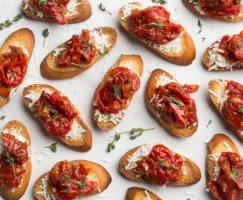 Crostini with tomato jam artfully displayed with fresh herbs