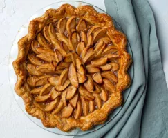 Full dutch apple pie sitting on a blue napkin