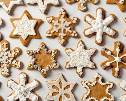 Gingerbread spiced sugar cookies shaped like stars and snowflakes with royal icing and sprinkles